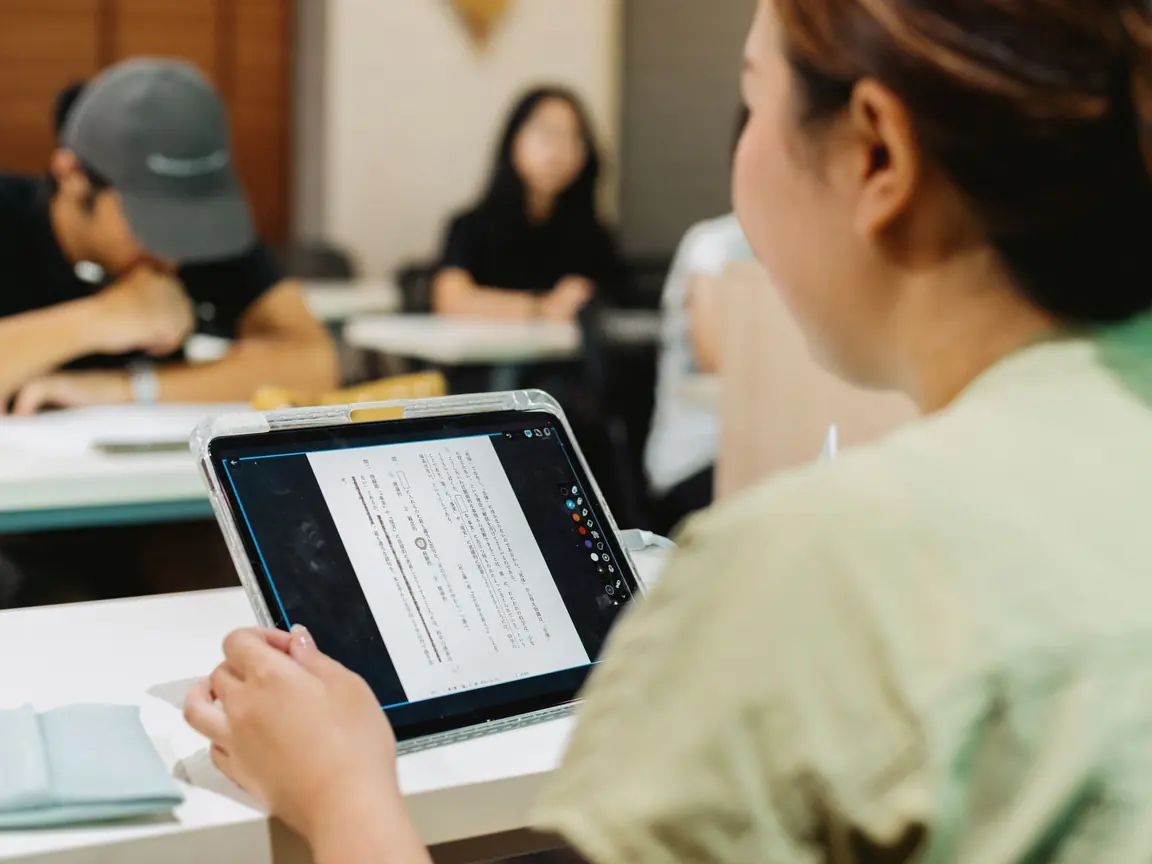 A student in a Tokyo classroom reads a marked-up text on her tablet